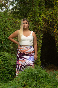 Portrait of young woman against plants