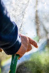 Close-up of hand with garden hose