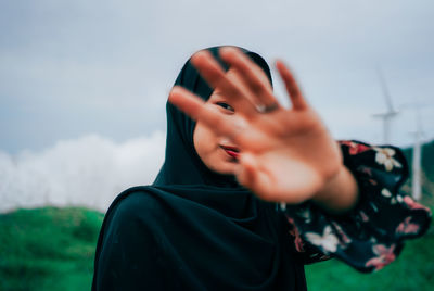 Portrait of woman standing against sky