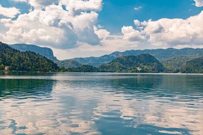 Scenic view of lake by mountains against sky