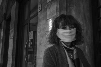 Portrait of woman standing against wall