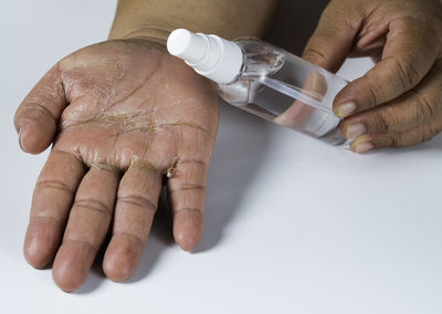 Close-up of man holding hands over white background