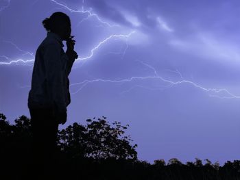 Silhouette woman standing against sky during sunset