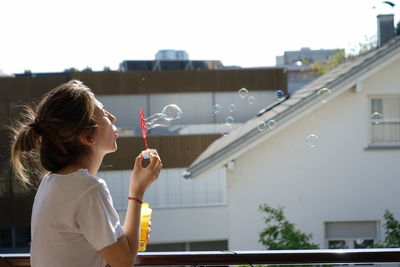 Full length of woman holding bubbles