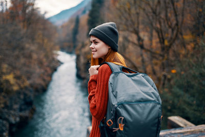 Young woman looking away while standing during autumn