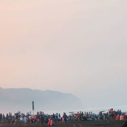 Group of people on mountain against sky