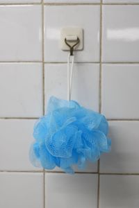 Close-up of bathing sponge hanging against wall