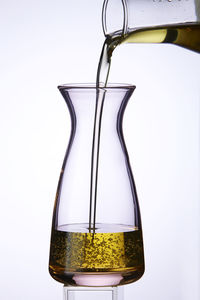 Close-up of liquid in glass jar against white background