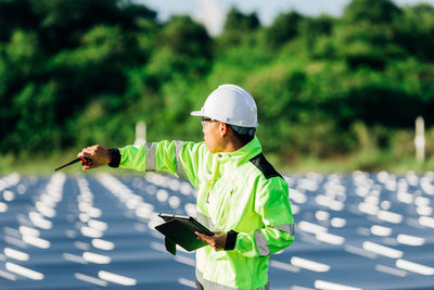 Asian engineer with digital tablet  in his hand who plans to expand the plant with solar panels. 