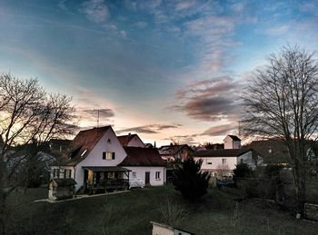 Houses in town against cloudy sky