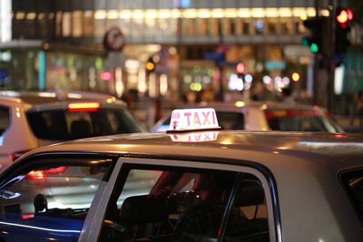 Cars on illuminated street at night