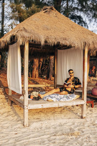 Man sitting in cabana on vacation at beach