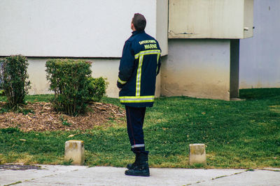 Rear view of man standing against building