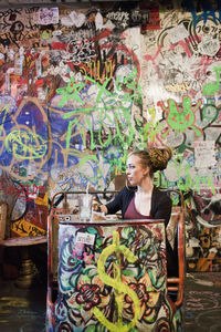 Woman looking at graffiti on wall