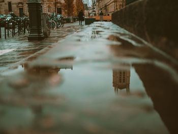 Reflection of building in puddle on street