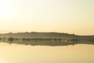 Scenic view of lake against clear sky during sunrise