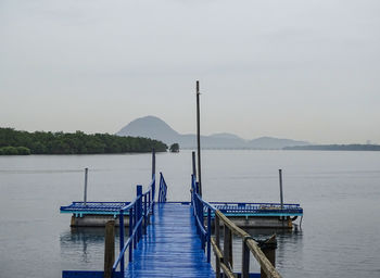 Pier on lake against sky