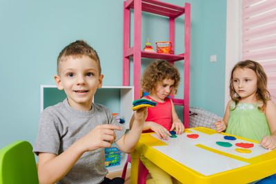 Portrait of smiling girl sitting on table