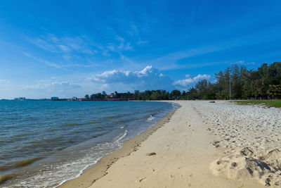 Scenic view of beach against blue sky