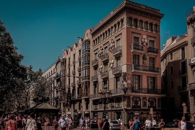 Crowd in city against sky