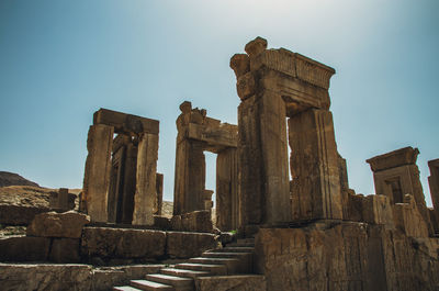 Low angle view of old ruins against clear blue sky