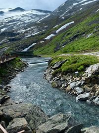 Scenic view of river amidst mountains against sky