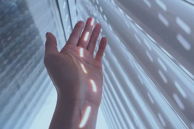 Sunlight falling on hand amidst white walls