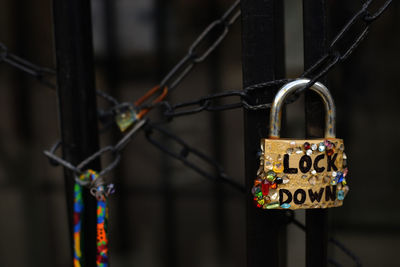 Close-up of padlocks hanging on fence