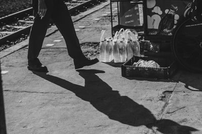 Low section of man standing on footpath in city