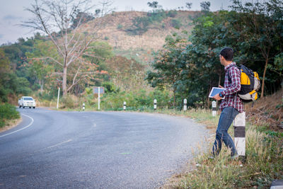 Man holding umbrella while standing on road