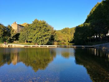 Scenic view of lake by trees against clear sky