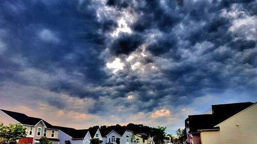 Houses in town against cloudy sky