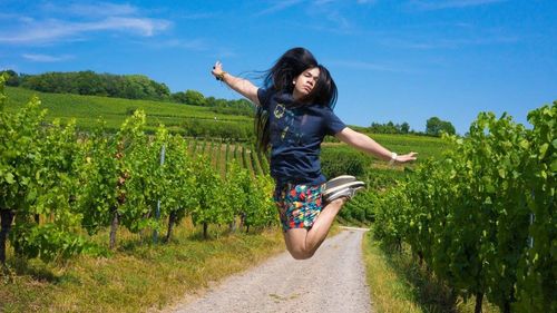 Full length of young woman walking on field