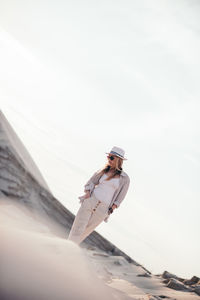 Portrait of woman with sunglasses standing against sky