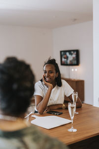 Young woman talking to friend at home