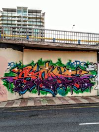 Graffiti on retaining wall by bridge