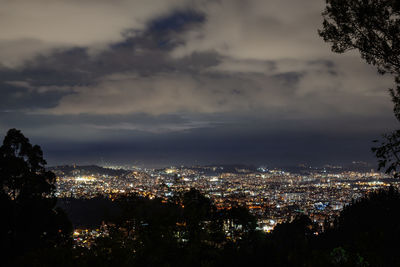 Illuminated cityscape against sky at night