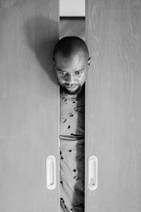 Portrait of boy standing by door at home