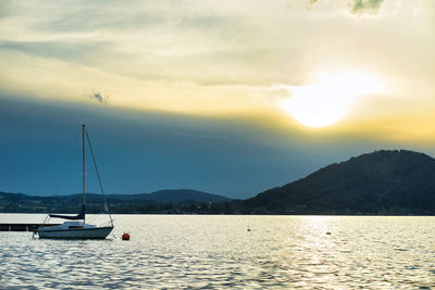 Sailboats sailing on sea against sky during sunset