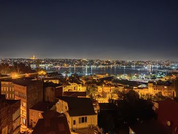 High angle view of illuminated cityscape against sky at night