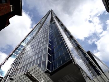 Low angle view of modern building against cloudy sky