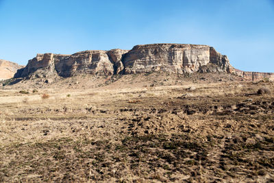 Rock formations on landscape against clear sky