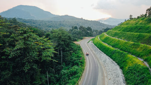 Panoramic view of road amidst trees and mountains against sky