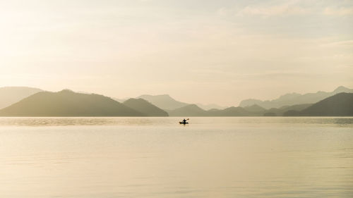 Scenic view of sea and mountains against sky