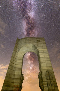 Low angle view of tower against sky at night