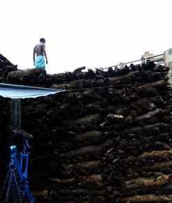 Stack of man sitting on rocks against wall