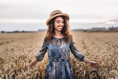 Portrait of smiling young woman standing in field