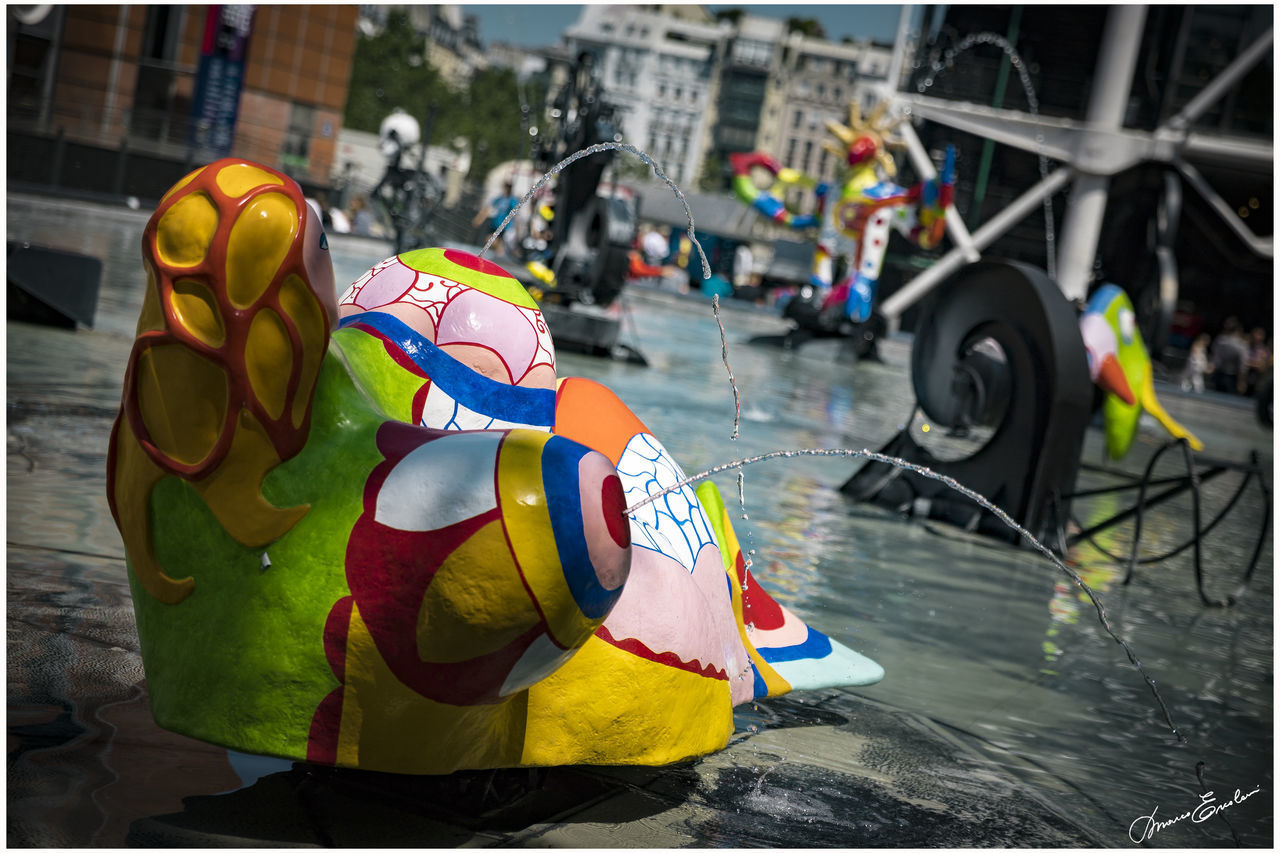 MULTI COLORED FLAGS ON CITY IN WATER