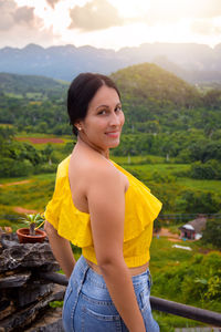 Portrait of smiling young woman standing on mountain