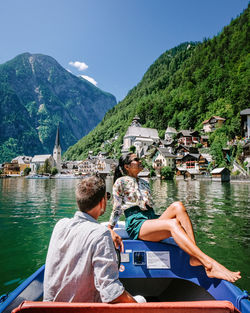 People on boat in lake against mountains